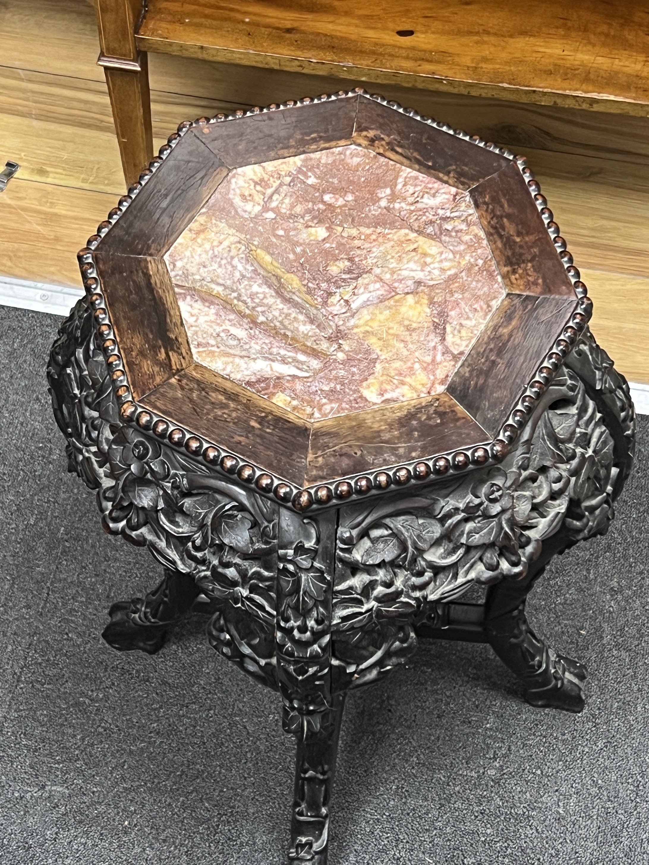 A Chinese octagonal marble topped hardwood jardiniere stand, width 38cm, height 61cm